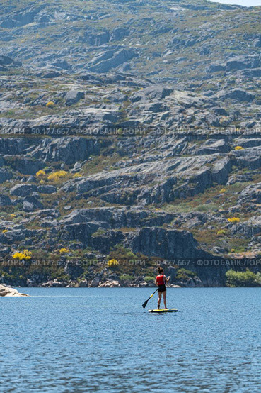 Stand up paddleboarding on lake. Watersport on lake. Tourist outdoor activity at Lagoa Comprida, Serra da Estrela National Park in Portugal. Стоковое фото, агентство Ingram Publishing / Фотобанк Лори