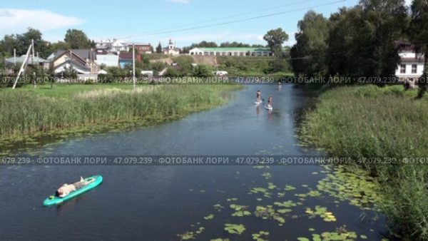 Старинный русский город Суздаль. Сапы плывут по реке Каменка. Июль. The ancient Russian city Suzdal. Saps float along the Kamenka River. July. Стоковое видео, видеограф Горшков Александр / Фотобанк Лори