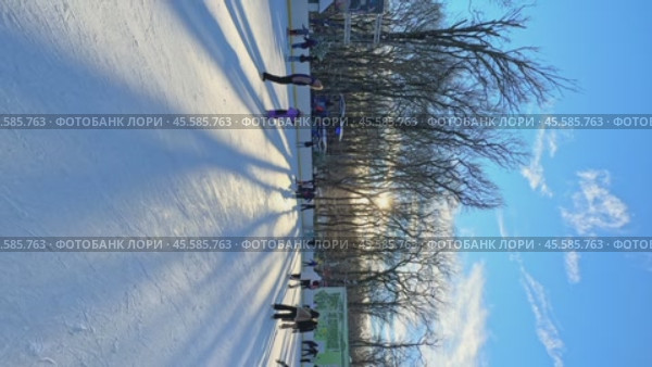 Ставрополь, парк Победы - Люди катаются на коньках на открытом катке в городском парке. Зимний городской пейзаж с толпой людей на открытом катке. Новогодние и Рождественские каникулы. Вертикальное видео. Редакционное видео, видеограф Ирина Михайличенко / Фотобанк Лори