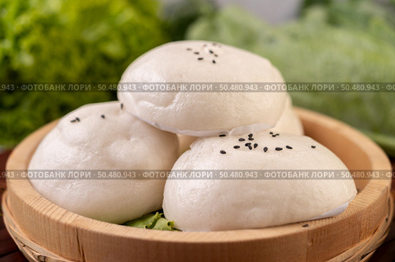 Steamed buns in a wooden dish on a wooden grill. Selective focus. Стоковое фото, агентство Ingram Publishing / Фотобанк Лори