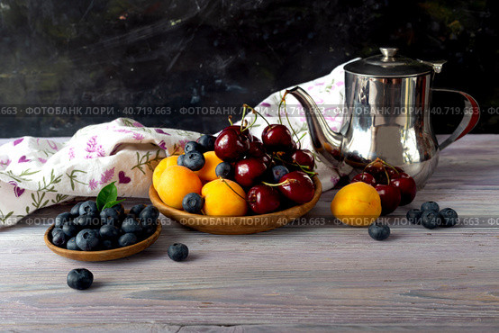 Still life with apricots, cherries and blueberries on a wooden table. Стоковое фото, фотограф Татьяна Ляпи / Фотобанк Лори