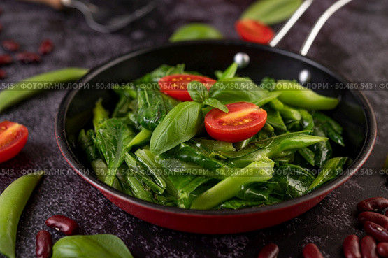 Stir-Fried Kale in Oyster Sauce on a Pan with Peanuts, Peppers, Tomatoes and Red Beans on a Cement Floor. Стоковое фото, агентство Ingram Publishing / Фотобанк Лори