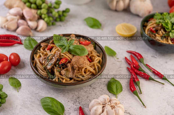 Stir fry the spaghetti put the pork in a bowl with pepper seeds, chilies, garlic, tomatoes, lettuce, lemon, and basil. Стоковое фото, агентство Ingram Publishing / Фотобанк Лори