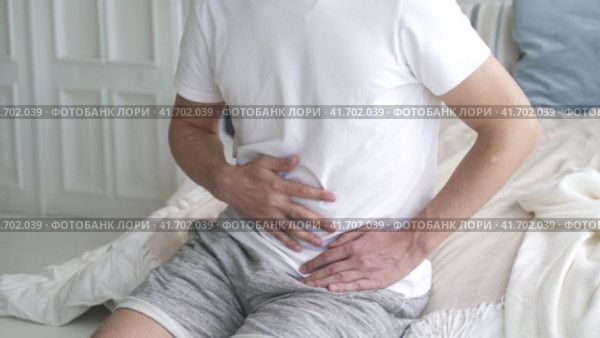 Stomach ache, man with abdominal pain suffering at home, health problems concept. Стоковое видео, видеограф Станислав Тарко / Фотобанк Лори