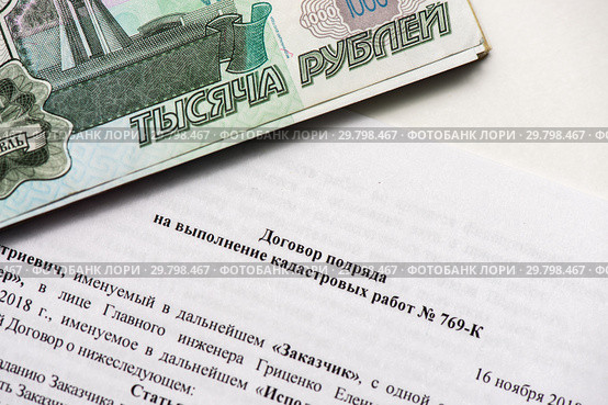 Стопка тысячных денег и договор подряда на выполнение кадастровых работ (2019 год). Редакционное фото, фотограф Игорь Низов / Фотобанк Лори