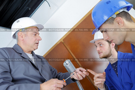 Student questioning instructor holding screwdriver and screws. Стоковое фото, агентство Ingram Publishing / Фотобанк Лори