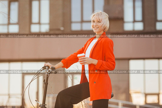 stylish blonde woman posing with her bicycle 3. Стоковое фото, агентство Ingram Publishing / Фотобанк Лори