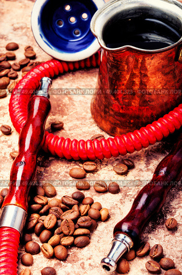 Stylish coffee jezva with coffee and hookah mouthpiece.Arabian shisha and coffee.Shisha Concept. Hookah with aroma coffee. Стоковое фото, агентство Ingram Publishing / Фотобанк Лори
