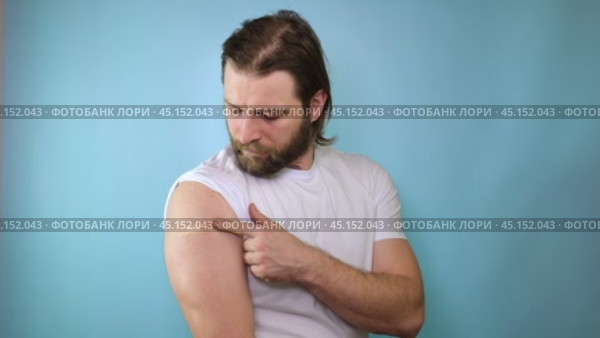 Successful Covid-19 Vaccination. Vaccinated Man Gesturing Okay And Showing Arm With Bandage After Vaccine Injection, Posing Wearing Antiviral Protective Face Mask, blue Background. Стоковое видео, видеограф Марина Демидюк / Фотобанк Лори