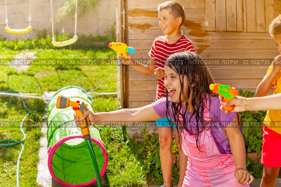 Summer fun - girl shoot water gun in group of kids. Стоковое фото, фотограф Сергей Новиков / Фотобанк Лори