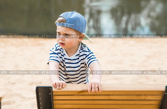 Summer lifestyle. A cute little boy is having fun playing in a modern outdoor playground. The concept of family entertainment and leisure. Стоковое фото, фотограф Photojuli / Фотобанк Лори