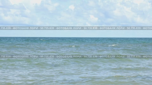 Sunny beach with a turquoise ocean in the background. Sea waves near the tropical coast on a sunny day. Cruise. Landscape of a summer sea beach with white sand and shells. Travel concept footage. Стоковое видео, видеограф Ирина Михайличенко / Фотобанк Лори