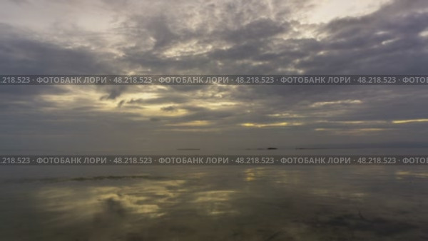 Sunset over calm waters with reflections and dramatic clouds. Стоковое видео, видеограф Михаил Коханчиков / Фотобанк Лори