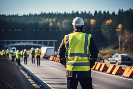 Supervisor wearing hard hat and safety vest overseeing road construction project. Стоковое AI-изображение, AI-художник Иван Рябоконь / Фотобанк Лори