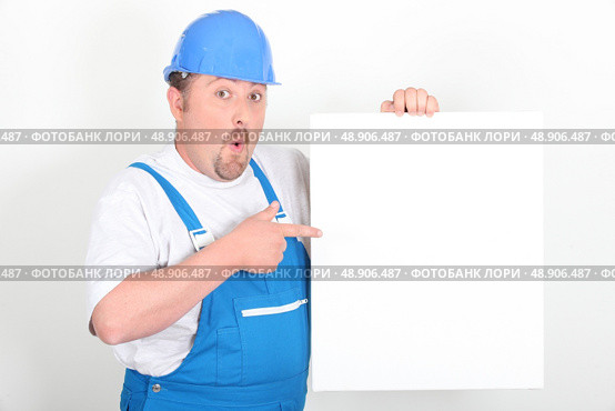 Surprised tradesman holding a blank sign. Стоковое фото, агентство Ingram Publishing / Фотобанк Лори