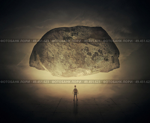 Surrealistic image as a man, with a bag in his back, stand in a foggy street below a huge squeezing rock. Life pressure and stress concept. Стоковое фото, агентство Ingram Publishing / Фотобанк Лори