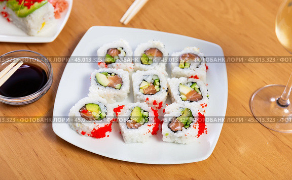 Sushi roll uramaki - tobiko roll with salmon, avocado, pepino, tobiko. Стоковое фото, фотограф Яков Филимонов / Фотобанк Лори