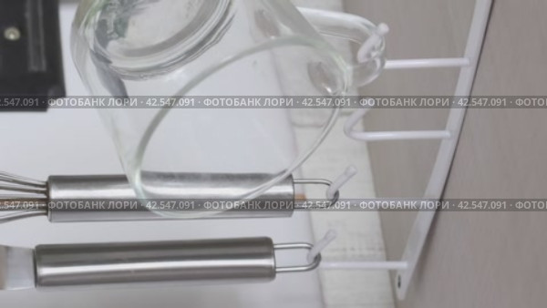 Suspension holder with hooks for utensils. Fixed to the closet. Utility hangs on hooks. Review of purchases. Vertical video. Close-up. Стоковое видео, видеограф Vadzim Yakubovich / Фотобанк Лори