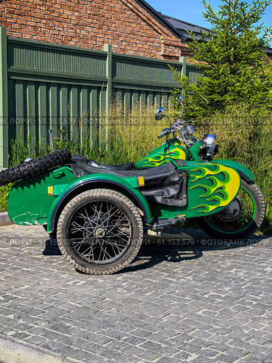 Suzdal, Vladimir Oblast, Russia - 24.07.2025. Ural M-67-36 Motorcycle with Flames decor in Driveway. Стоковое фото, фотограф Ольга Губская / Фотобанк Лори