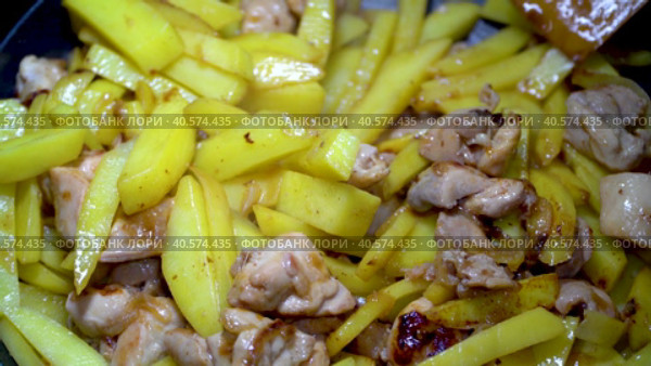 Свежая картошка жарится на сковороде с куриным мясом и репчатым луком. Аппетитный жареный картофель. Женская рука перемешивает картошку деревянной лопаткой. Стоковое видео, видеограф Руслан Лесков / Фотобанк Лори