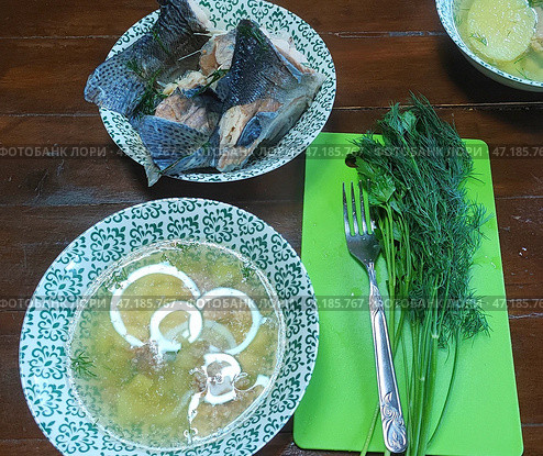 Свежая уха в тарелке, кусочки радужной форели, укроп. Fresh fish soup in a bowl, pieces of rainbow trout, dill. 新鲜的鱼汤在一个碗里，虹鳟鱼，莳萝片。 Стоковое фото, фотограф Денис Баданин / Фотобанк Лори