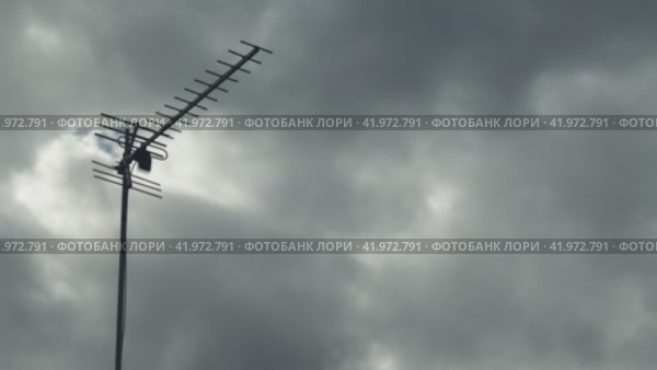 Таймлапс телевизионной антенны на фоне быстро летящих серых облаков. Крупный план. Плавное движение камеры. Стоковое видео, видеограф Воловодов Владимир / Фотобанк Лори