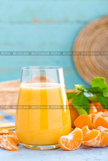 Tangerines, peeled tangerines and tangerine juice in glass. Mandarine juice and fresh fruits with leaves. Стоковое фото, агентство Ingram Publishing / Фотобанк Лори