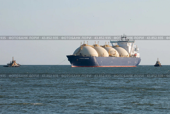 Танкер для перевозки сжиженного природного газа "Cygnus Passage" в море с буксирами (2024 год). Редакционное фото, фотограф Сергей Крамарев / Фотобанк Лори