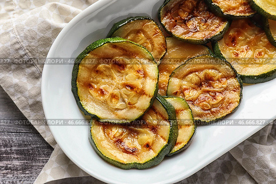 Тарелка с вкусным жареным цуккини на деревянном столе, крупным планом. Стоковое фото, фотограф Pixel_shot / Фотобанк Лори