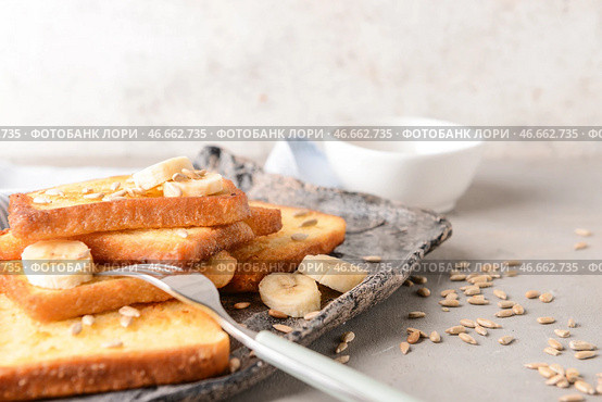 Тарелка с вкусными французскими тостами и бананом на сером столе. Стоковое фото, фотограф Pixel_shot / Фотобанк Лори