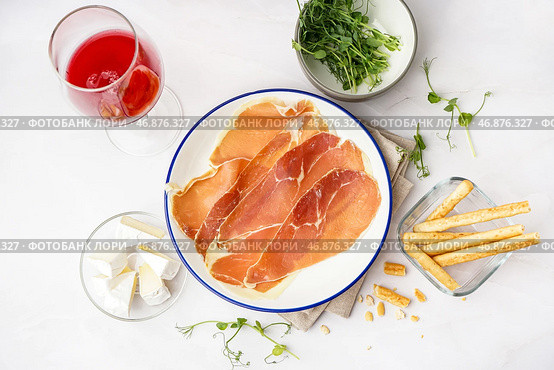 Тарелка с вкусными ломтиками хамона на светлом фоне. Стоковое фото, фотограф Pixel_shot / Фотобанк Лори