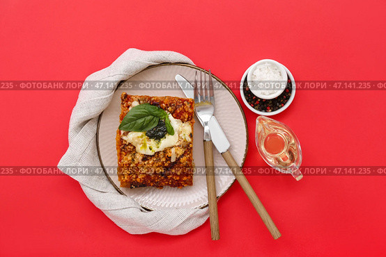 Тарелка вкусного итальянского пирога с моцареллой, соусом песто, специями и маслом на красном фоне. Стоковое фото, фотограф Pixel_shot / Фотобанк Лори