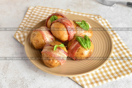 Тарелка вкусного печеного картофеля с беконом на светлом фоне. Стоковое фото, фотограф Pixel_shot / Фотобанк Лори