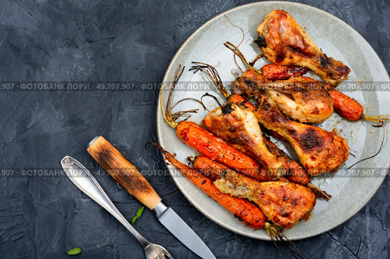 Tasty chicken legs baked with carrots on plate. Space for text.. Roasted chicken drumstick. Стоковое фото, агентство Ingram Publishing / Фотобанк Лори