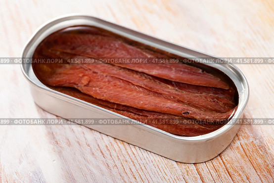 Tasty preserved anchovy fillet in oil on wooden surface, nobody. Стоковое фото, фотограф Яков Филимонов / Фотобанк Лори
