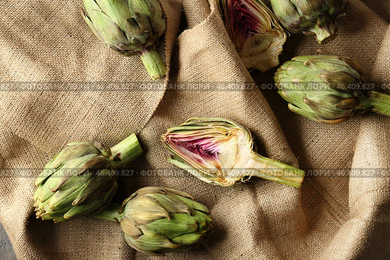 Tasty raw artichokes on sackcloth. Стоковое фото, фотограф Pixel_shot / Фотобанк Лори
