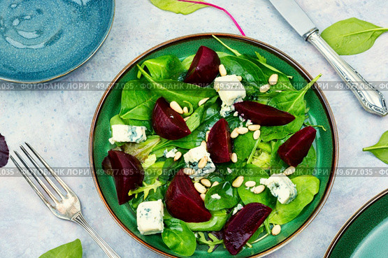 Tasty salad with beets, blue cheese, herbs and pine nuts on gray background. Fresh salad with beets, cheese and greens. Стоковое фото, агентство Ingram Publishing / Фотобанк Лори