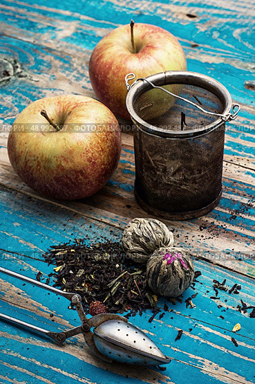 tea leaves and red apple on wooden background.The image is tinted in vintage style. Стоковое фото, агентство Ingram Publishing / Фотобанк Лори
