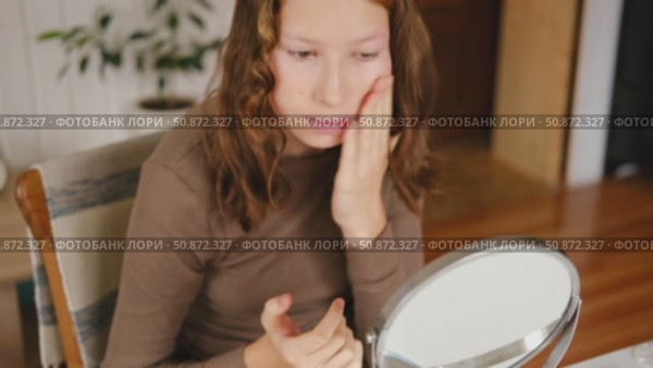 Teen Girl putting on makeup looking at mirror. Beautiful Teenager caring her face. 14 years old female applied cosmetics. Natural beauty concept. Skin care, make-up. Daily make up. Beautiful Teenage. Стоковое видео, видеограф Марина Демидюк / Фотобанк Лори
