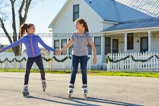 Teen girls group rolling skate in the street outdoor. Стоковое фото, агентство Ingram Publishing / Фотобанк Лори