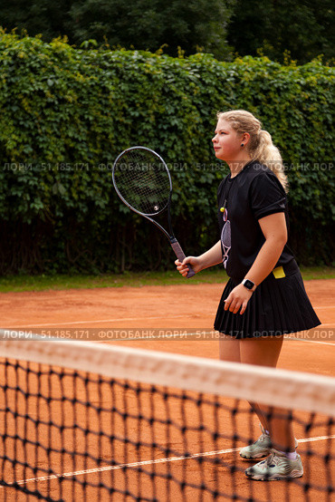 Teenage Girl Mastering Her Tennis Skills Under the Sun on an Outdoor Court. Стоковое фото, фотограф Aleksandr Golubev / Фотобанк Лори
