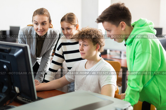 Teenagers studying with female teacher in information technology class. Стоковое фото, фотограф Яков Филимонов / Фотобанк Лори