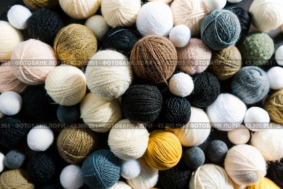 The background is made of balls of wool yarn . Needlework, textiles, knitting. Winter season, small business, handmade clothes. Стоковое AI-изображение, AI-художник Photojuli / Фотобанк Лори