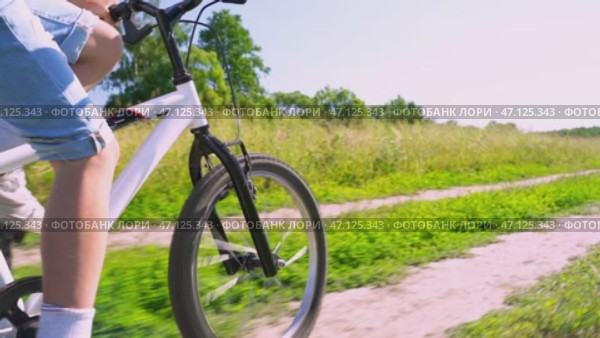 The boy rides a bicycle in the park. Стоковое видео, видеограф Igor Skripachev / Фотобанк Лори