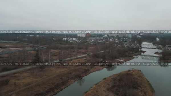 The camera flies over the cold autumn water of a river with an uninhabited island under a gloomy dark sky and opens a panorama of the opposite deserted shore. Стоковое видео, видеограф Ярославский Максим / Фотобанк Лори