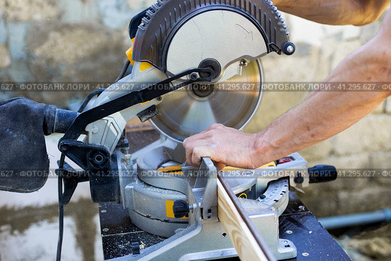The craftsman sawed a wooden board with a circular miter saw.Woodworking with a professional tool. Стоковое фото, фотограф Коханова Наталья / Фотобанк Лори