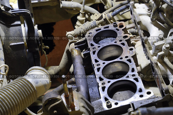 The cylinder block of the four-cylinder engine. Disassembled motor vehicle for repair. Parts in engine oil. Car engine repair in the service. Стоковое фото, фотограф Леонид Еремейчук / Фотобанк Лори