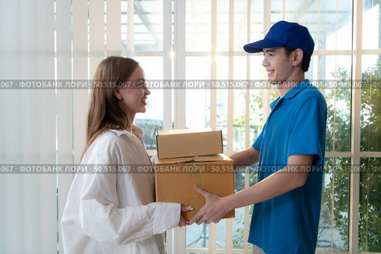 The delivery man brings the goods that the customer purchased and delivers them to the customer’s home. Стоковое фото, агентство Ingram Publishing / Фотобанк Лори