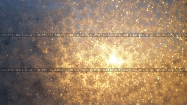 The frosty pattern on window glass occurs due to the condensation of water vapor on glass cooled below 0 degrees. Frost flowers, curls and crystals. Morning yellow-orange low winter sun on the horizon. Стоковое видео, видеограф Юлия Петровская / Фотобанк Лори