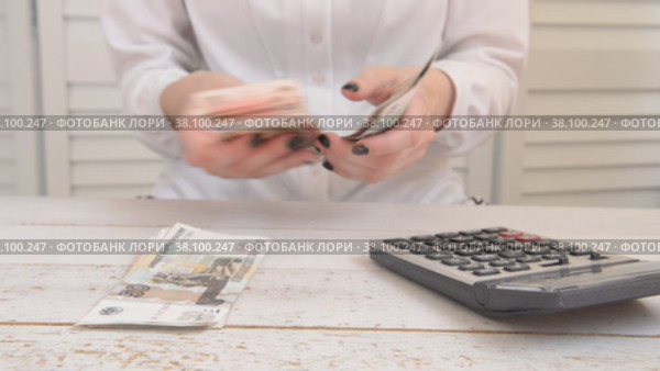The girl counts money using a calculator the concept of accounting. Стоковое видео, видеограф Катерина Белякина / Фотобанк Лори